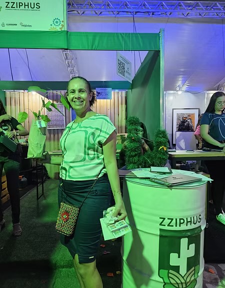 Integrante da Zziphus no estande do programa, com mudas para distribuição